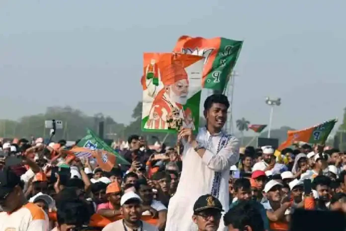 A supporter of Prime Minister Narendra Modi holds up a poster with multiple Modi portraits on the Brigade Parade Ground in Calcutta on Saturday. Picture by Sanat Kr Sinha/The Telegraph
